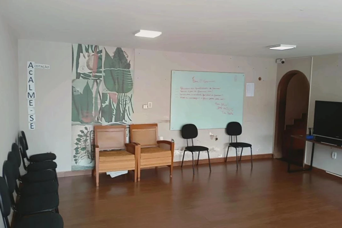 Sala de terapia em grupo com poltronas e piso de madeira